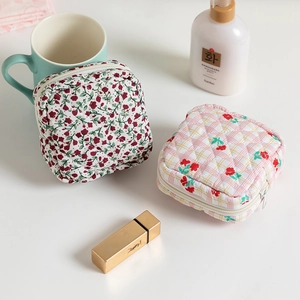 Quilted floral and checkered makeup bags with zippers on a cozy lifestyle background