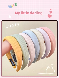 Detail of multi-color ribbed fabric headbands with handmade label in various pastel colors