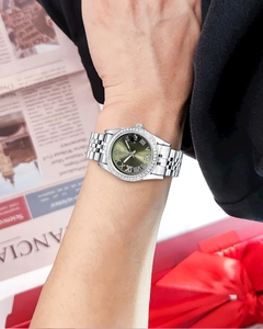 Close-up of silver steel watch with green dial and diamond bezel on woman's wrist