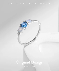 Macro view of S925 sterling silver ring with blue gemstone and opal on white stone