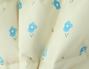 Macro shot of floral pattern fabric with blue flowers on beige twill woven material