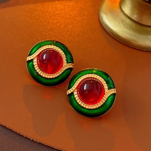 Gros plan de boucles d'oreilles vintage avec pierres rouges et émail vert sur métal doré