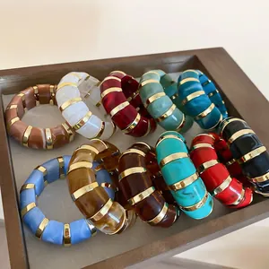 Colorful acrylic segment bracelets with gold metal spacers in a jewelry tray display