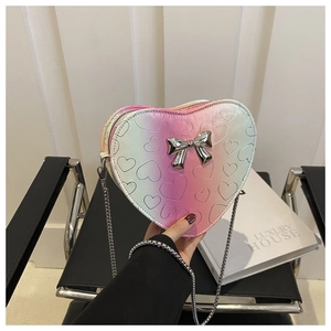 Detail of heart-shaped gradient bag featuring embossed patterns and a silver bow chain