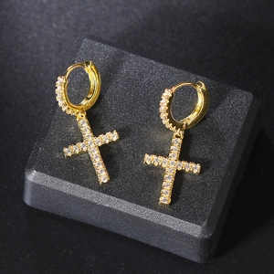 Gold-plated cross drop earrings with sparkling white cubic zirconia on a black display base