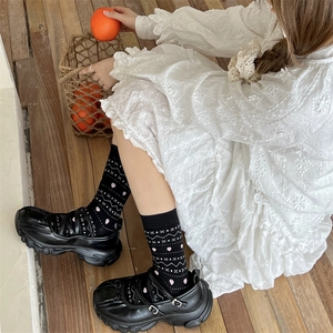 Vue détaillée de chaussettes à cœurs noires et de chaussures Mary Jane à semelles compensées