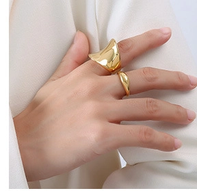 Close-up of gold minimalist rings featuring irregular wide band and classic smooth styles