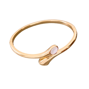 Gold-plated oval crossover bangle with white shell inlay on a clean white background
