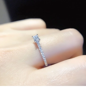 Close-up of emerald cut cubic zirconia ring with micro-pave setting on finger