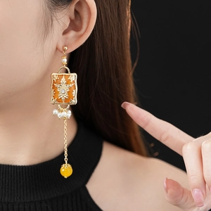 Macro shot of vintage gold flower earrings with pearls and crystal on female model