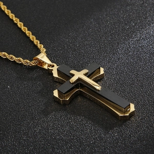 Macro view of triple-layered cross pendant with golden rope chain and matte black inlay