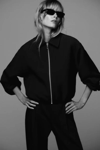 Détail de veste noire pour femmes avec col rabattu et fermeture éclair métallique argentée
