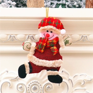 Hanging snowman Christmas ornament with red burlap fabric and festive plaid hat on a tree