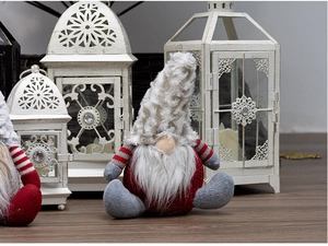 Close-up of Christmas gnomes with knit outfits and faux fur hats on wooden floor decor