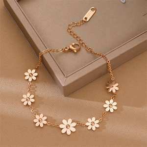 Elegant rose gold stainless steel daisy bracelet with seven charms on silk background