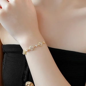 Detailed view of a gold-plated clover link bracelet with sparkling pavé zircons on the wrist