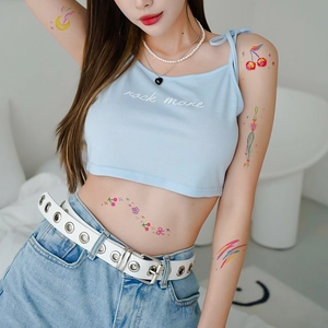 Cute colorful temporary tattoos with moon and cherry designs on female model arms