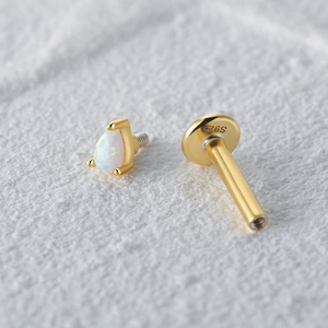 Macro detail of S925 sterling silver gold stud with teardrop opal and hallmark engraving