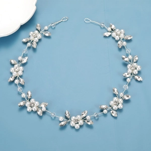 Silver bridal hair vine with white pearls and crystals on a light blue backdrop