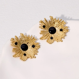 Detailed view of vintage gold and black irregular sunburst earrings on a white tray