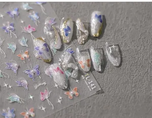Close-up of 5D relief butterfly nail stickers with pearlescent finish on grey fabric