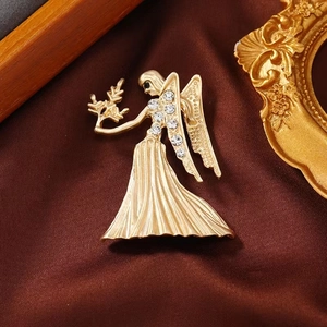 Vintage gold angel brooch with white rhinestones on silk background for luxury apparel