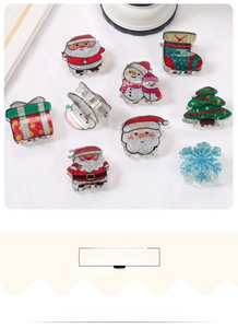 Detailed view of Christmas hair clips featuring santa, snowman and glittery trees