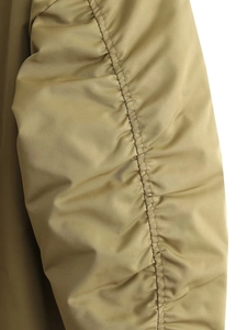 Detailed macro view of olive green nylon sleeve with sophisticated ruched design and texture