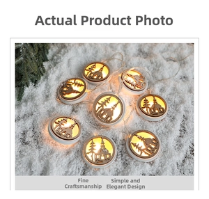 Detail of warm white LED Christmas lights with hollow carved wooden ornaments in snow