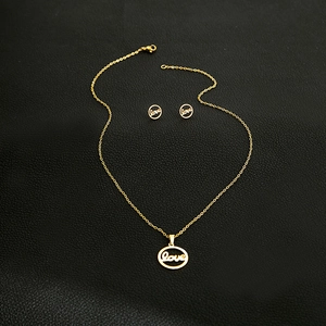 Macro view of gold stainless steel necklace and earrings set with hollow Love art design