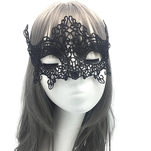 Detail showing an intricate black lace masquerade mask on a white model head