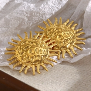 Detailed close-up of 18K gold-plated sun-shaped earrings with hammered metal texture