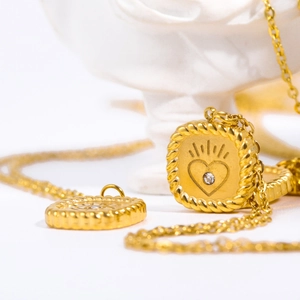 Gold tarot card necklace with heart zircon pendant and moon star coin on white stone