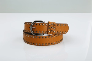 Detail of orange leather punk belt with silver metal rivets and classic buckle