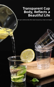 Clear disposable plastic cups shown stacked and filled with lemon water on black background