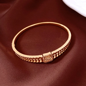 Gros plan d'un bracelet en or rose avec boucle carrée ajourée et strass étincelants