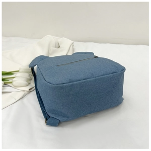 Close-up of blue canvas backpack with cute animal ears and durable zipper details