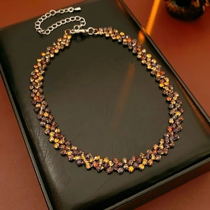 Détail de la chaîne ajustable d'un collier carré serti de strass couleur ambre