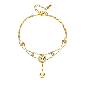 Detail view of double-layer gold anklet featuring tree of life charm and teardrop gems