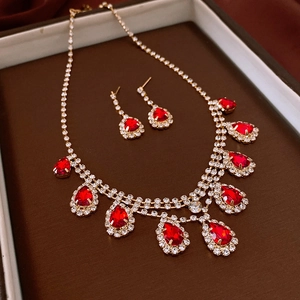 Macro detail of luxury water drop tassel necklace and earrings set with red rhinestones