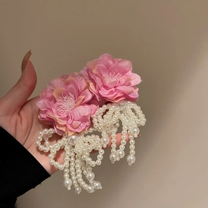 Detail of pink silk flowers and hanging white pearls on floral tassel earrings
