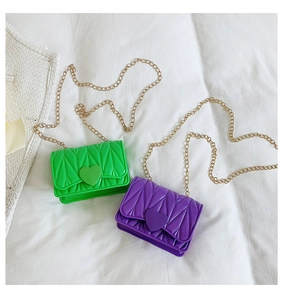 Detail of mini quilted crossbody bags with heart locks and golden chain straps