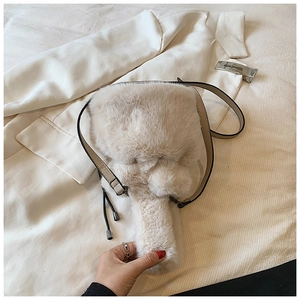 Détail de la texture douce du sac seau en peluche avec bandoulière en cuir beige