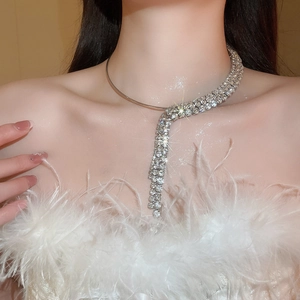 Detail of silver tassel necklace with rhinestones worn by a model in a luxury scene