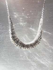 Macro shot of multi-row diamond fringe necklace with rainbow light flare details