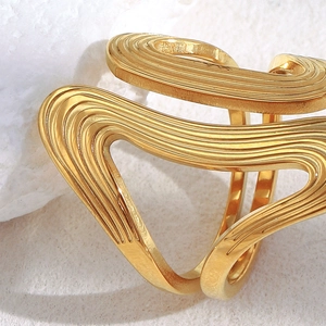 Détail macro d'une bague en acier inoxydable plaqué or 18 carats à texture ondulée