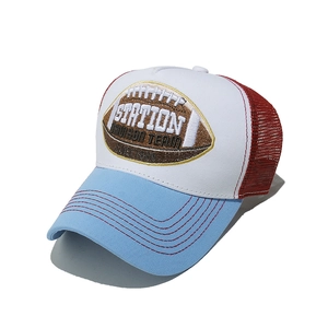 Detail of rugby themed embroidery on a tri-color mesh trucker hat in red white and blue