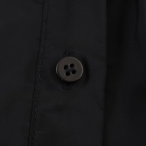 Detail of black shirt dress fabric featuring premium four-hole resin buttons and fine stitching