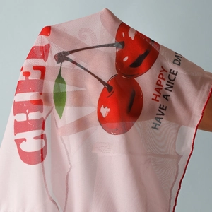 Close-up of pink and white mesh bikini cover-up with vibrant red cherry patterns