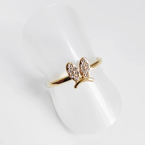 Detail view of gold-plated butterfly ring with sparkling pavé crystals on a white display